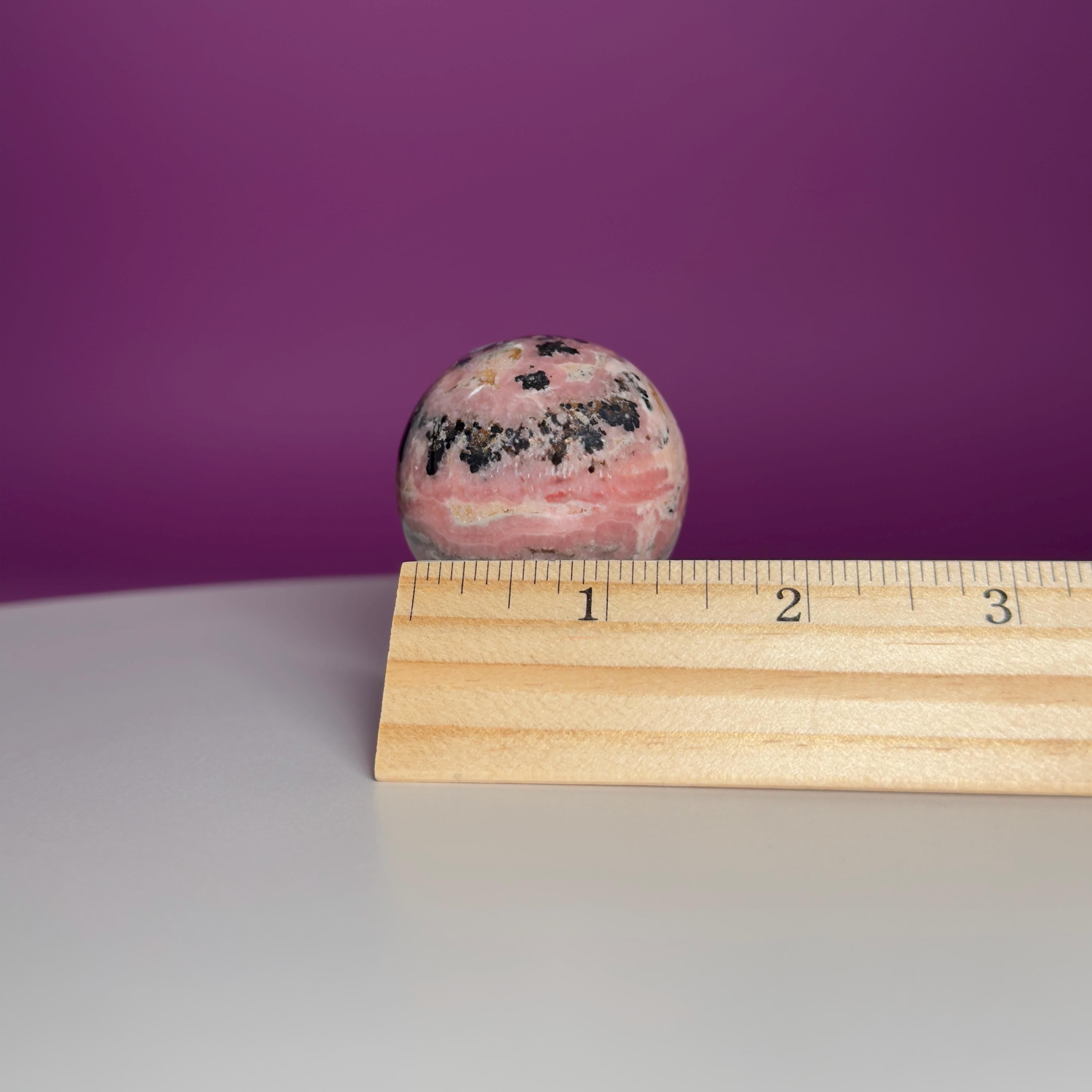 Rhodonite Sphere with Glass Stand – 144g Pink and Black Crystal for Emotional Healing